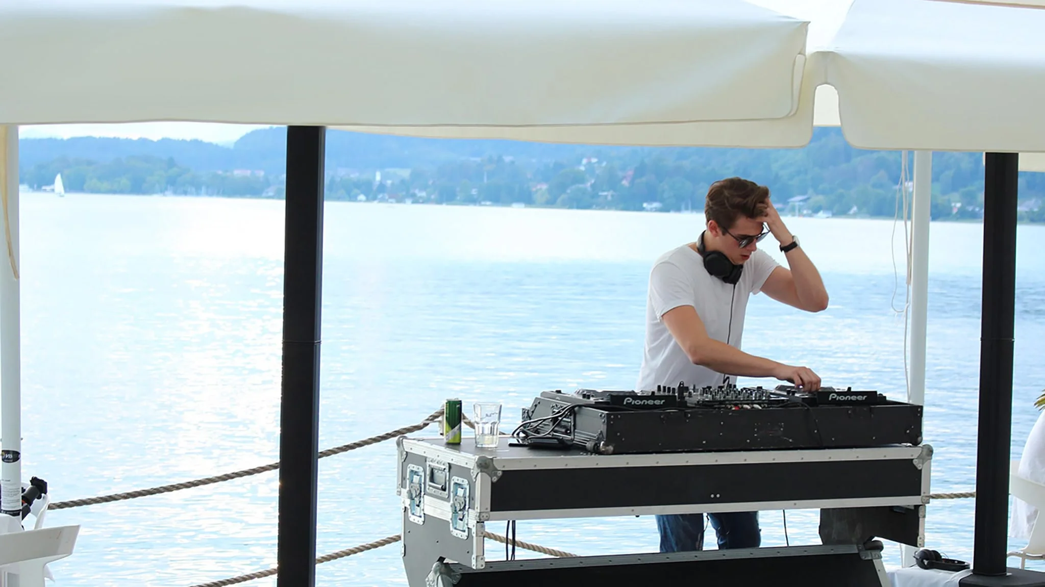 Plie at the decks under a sunshade, the Wörthersee behind him